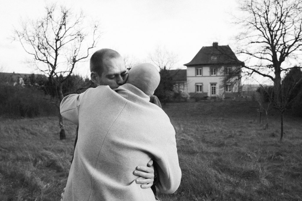 Couple s'embrassant dans leur jardin pendant une séance engagement en Moselle