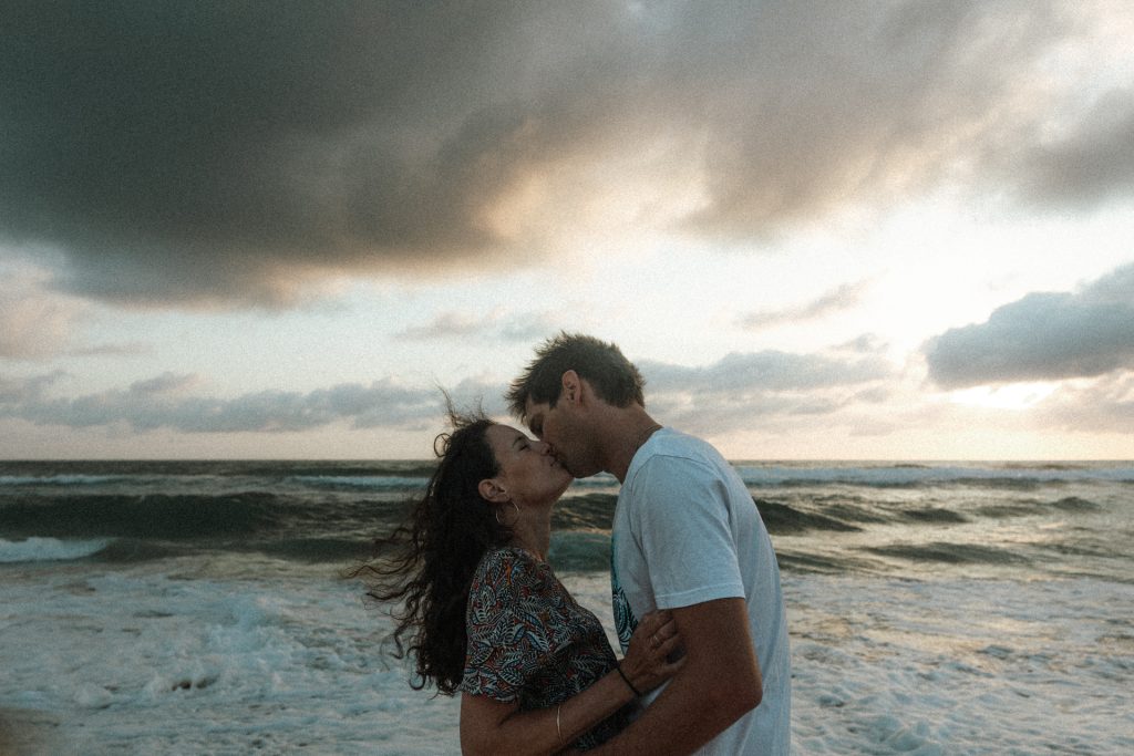 Couple qui s'embrasse sur la plage pendant une séance engagement à Lacanau Océan
