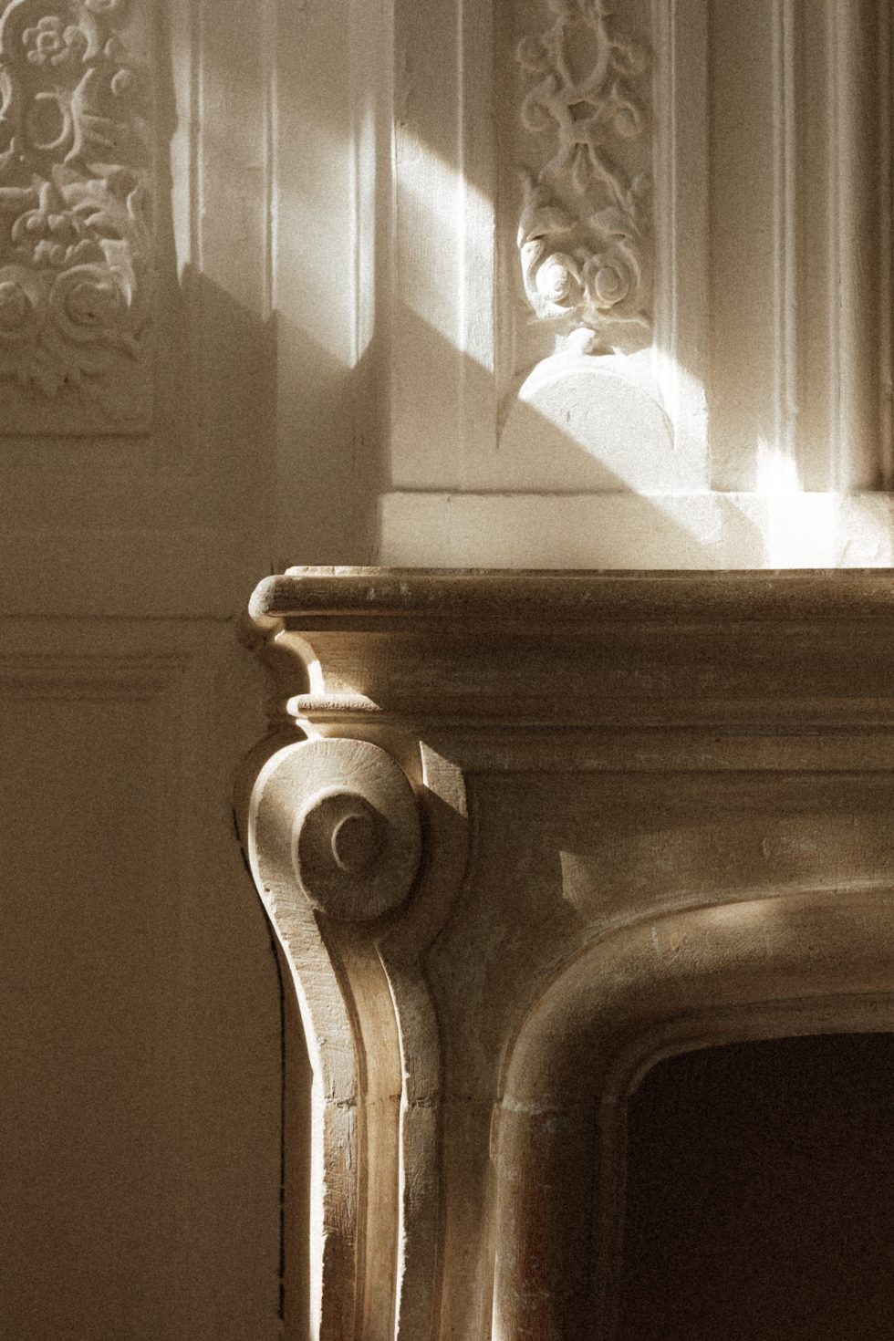 Cheminée de la chambre nuptiale du Château de Vandeléville baignée par un rayon de soleil