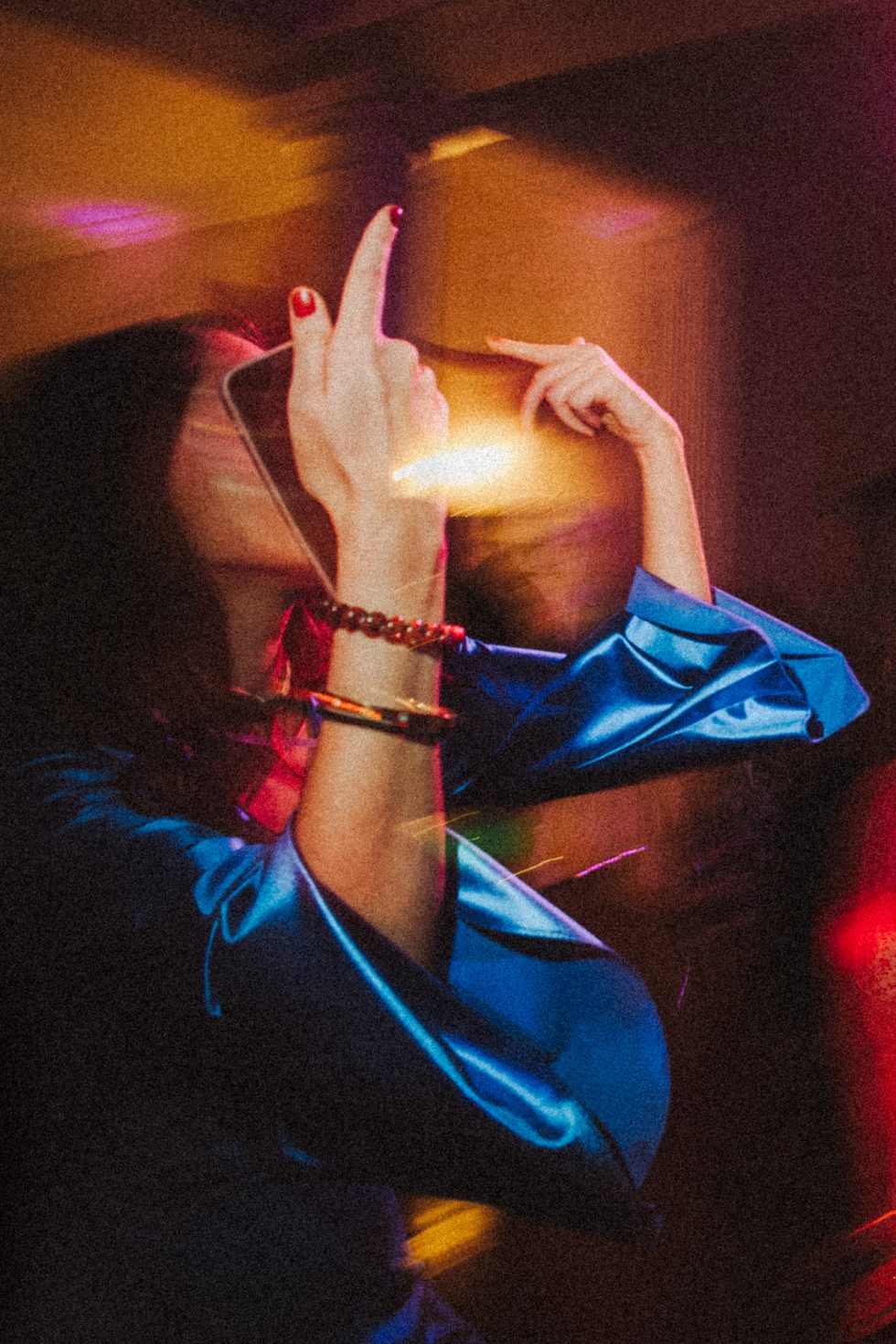 Une invitée danse pendant la soirée de mariage au Château de Vandeléville. Son visage est masqué par sa main