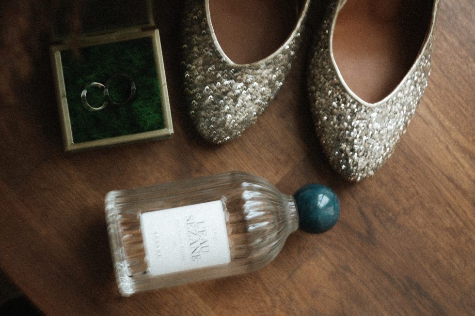 Détail poétique des préparatifs au Château-Ferme d'Aboncourt : alliances, parfum et souliers pailletés de la mariée.