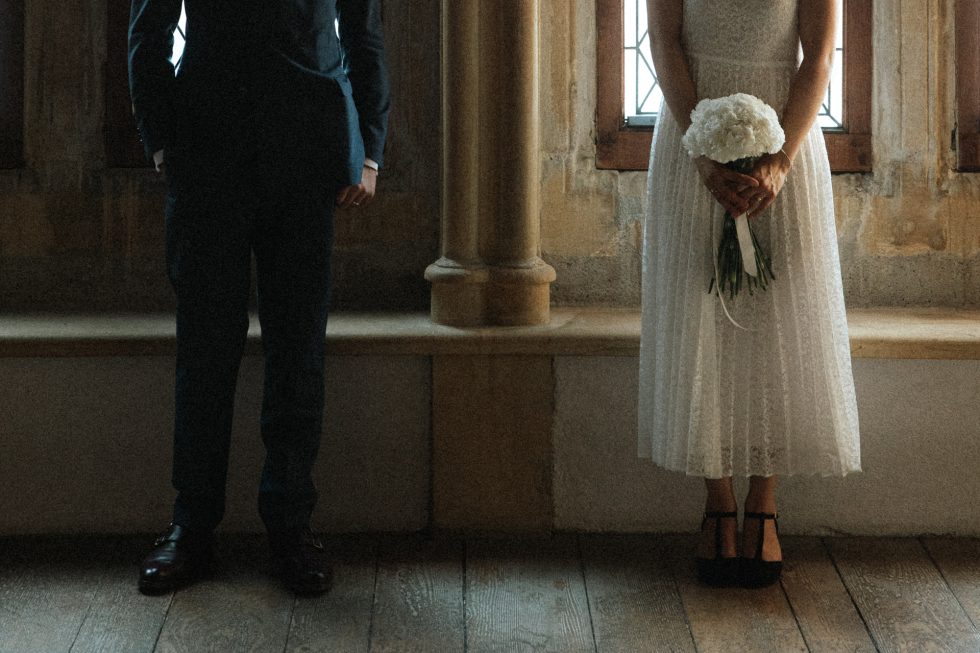 Couple de mariés au Musée de la Cour d'Or à Metz. Détail élégant du marié en costume et de la mariée tenant son bouquet