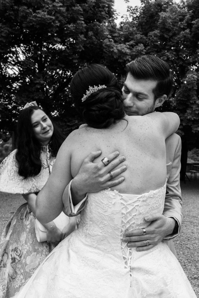 Etreinte entre la mariée et son frère sous les yeux émus de sa belle-sœur
