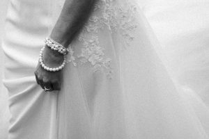 Détail de la main de la mariée tenant sa robe