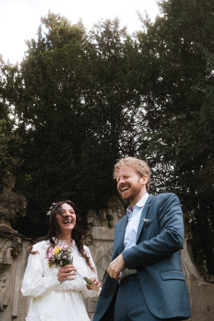 Les mariés rient aux éclats pendant les photos de couple au Parc de la Pépinière à Nancy