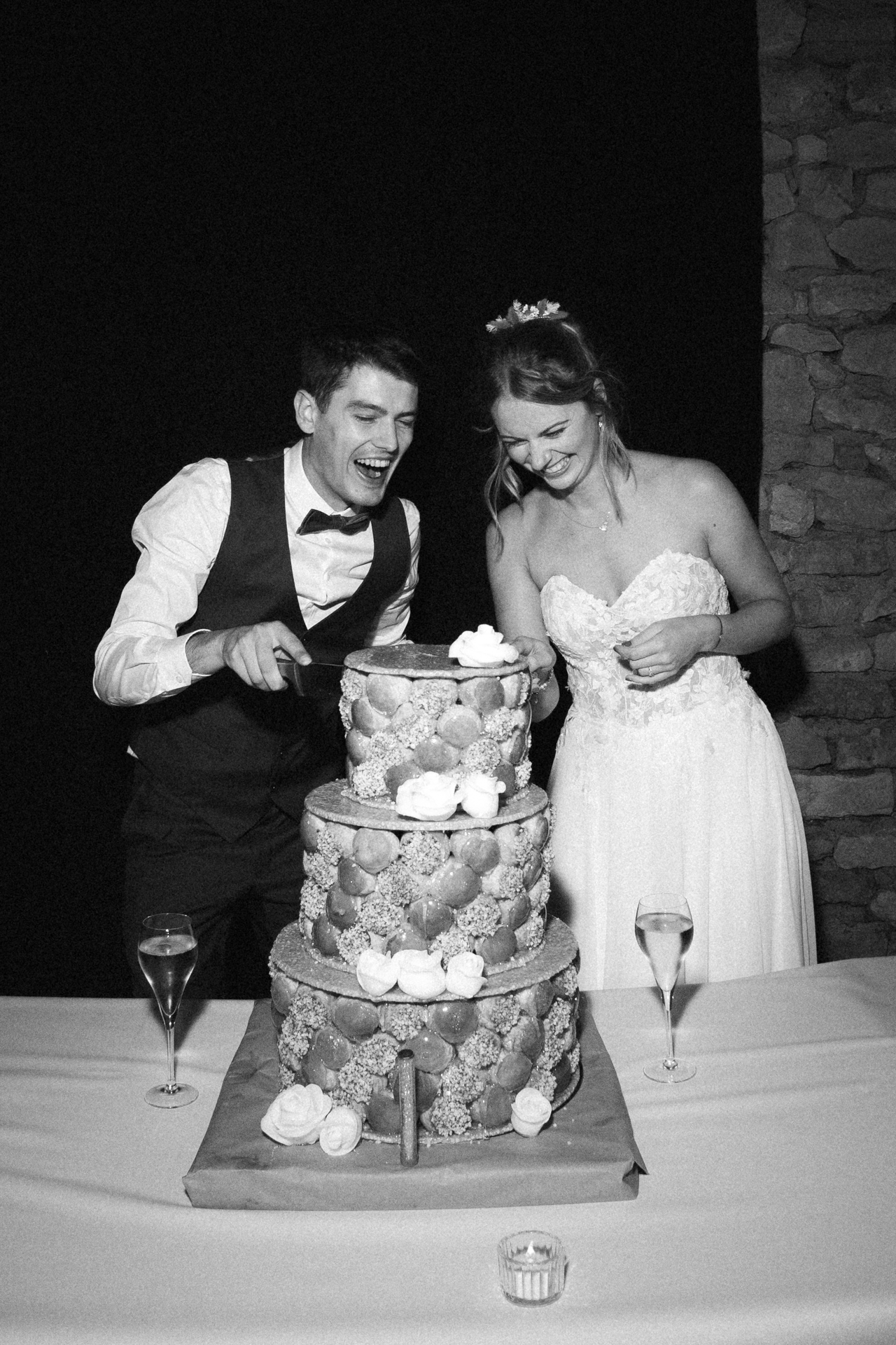 Les mariés rigolent pendant qu'ils découpent la pièce montée au Harras de la Vannoue