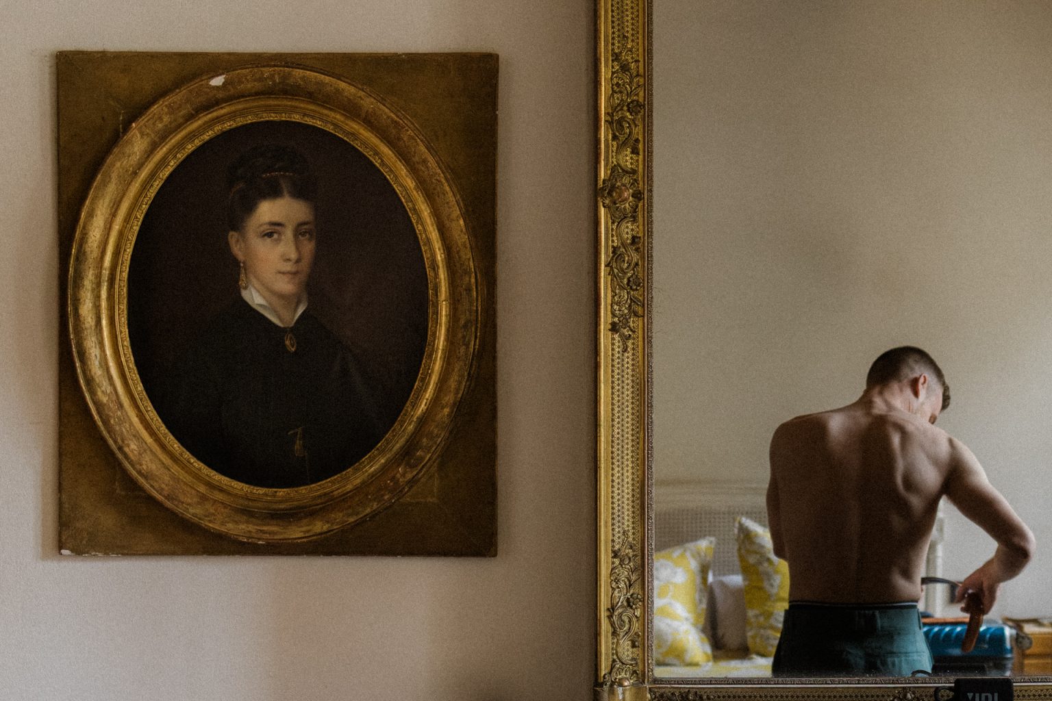 L'image du marié, de dos, en train de se préparer dans sa chambre d'hôtel à Metz se reflète dans le miroir.