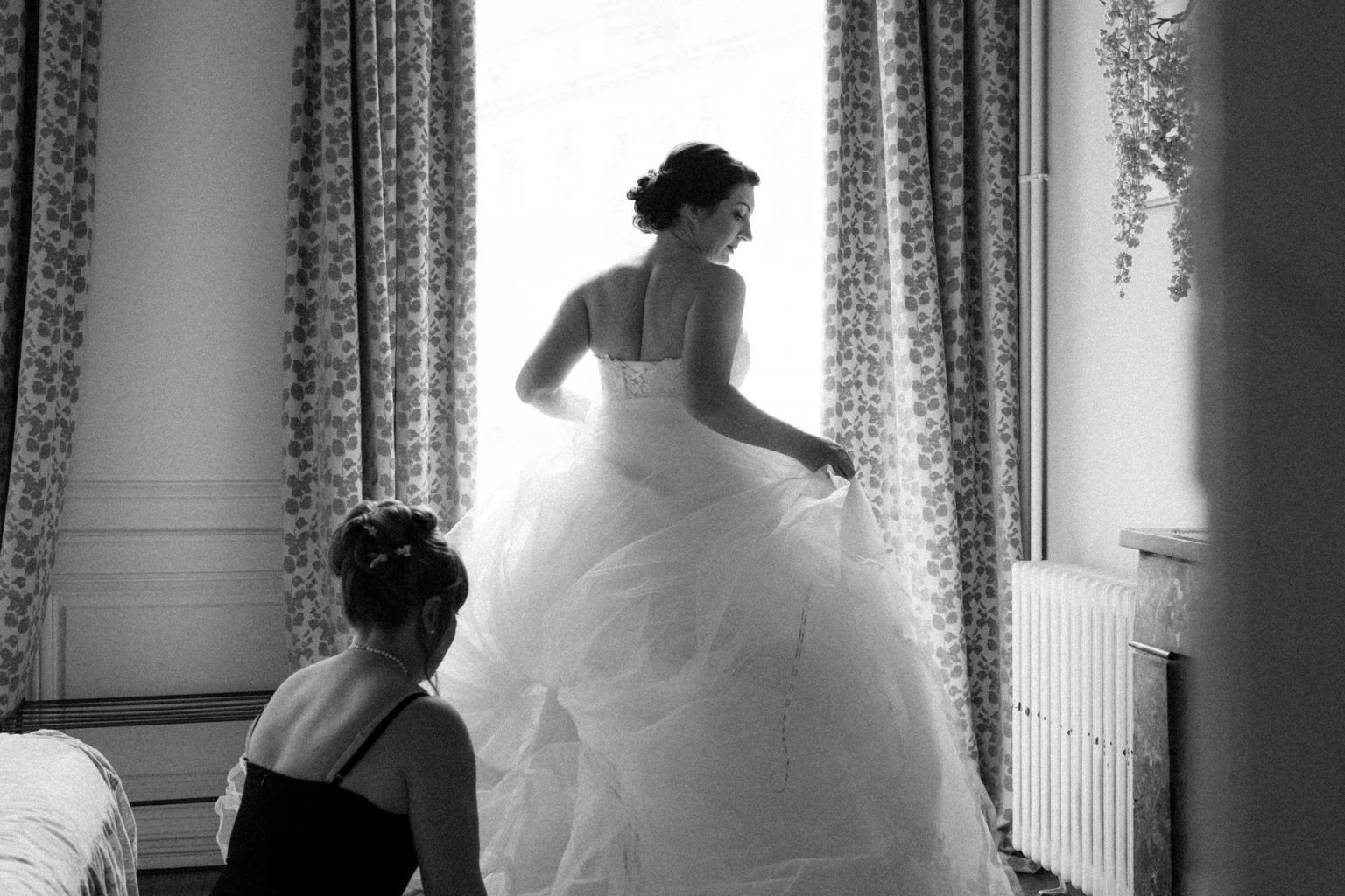 La mère de la mariée aide sa fille à placer le tulle de sa robe pendant les préparatifs dans un hôtel à Metz