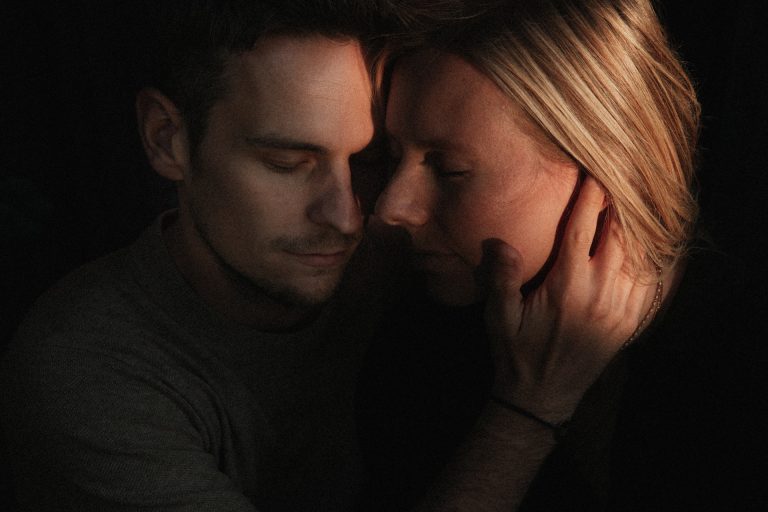 Moment tendre lors d'une séance couple à Metz. La lumière du soleil baigne le visage du couple. L'homme pose sa main délicatement sur le visage de sa compagne