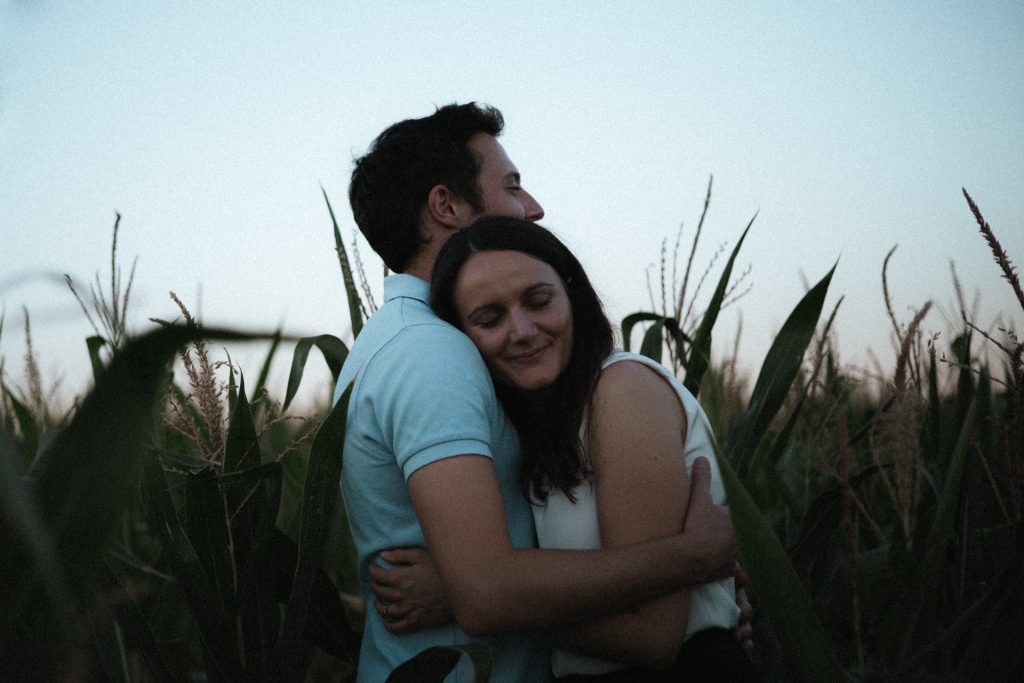 Couple qui s'enlace dans un champ de maïs en Moselle pendant une séance engagement