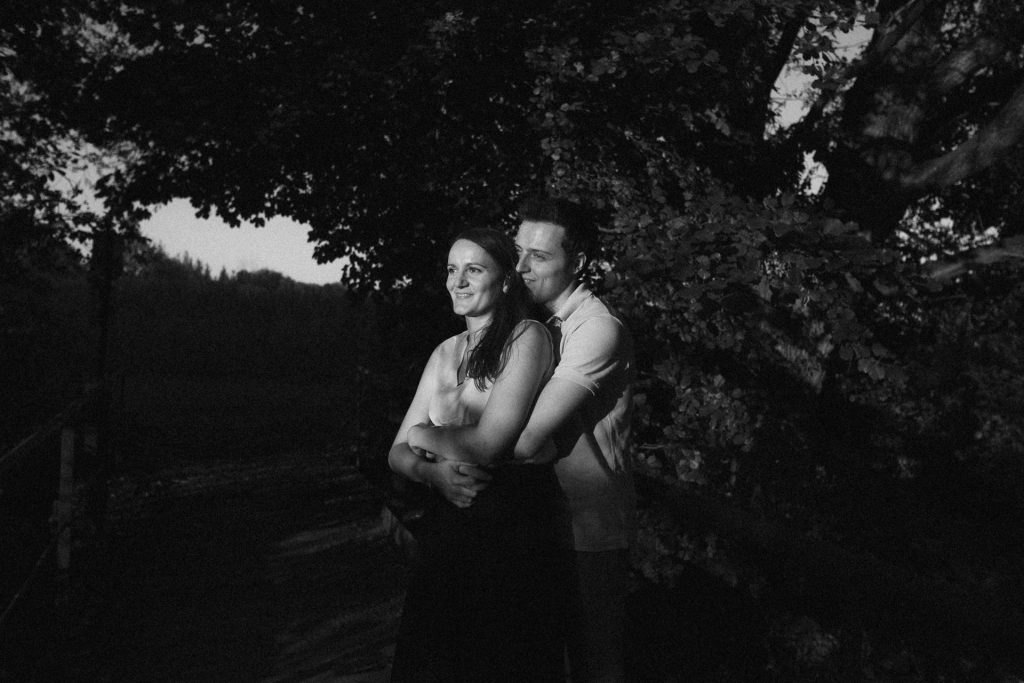 Couple qui s'enlace dans un champ de maïs en Moselle pendant une séance engagement. Leurs visages sont éclairés par la lumière du soleil