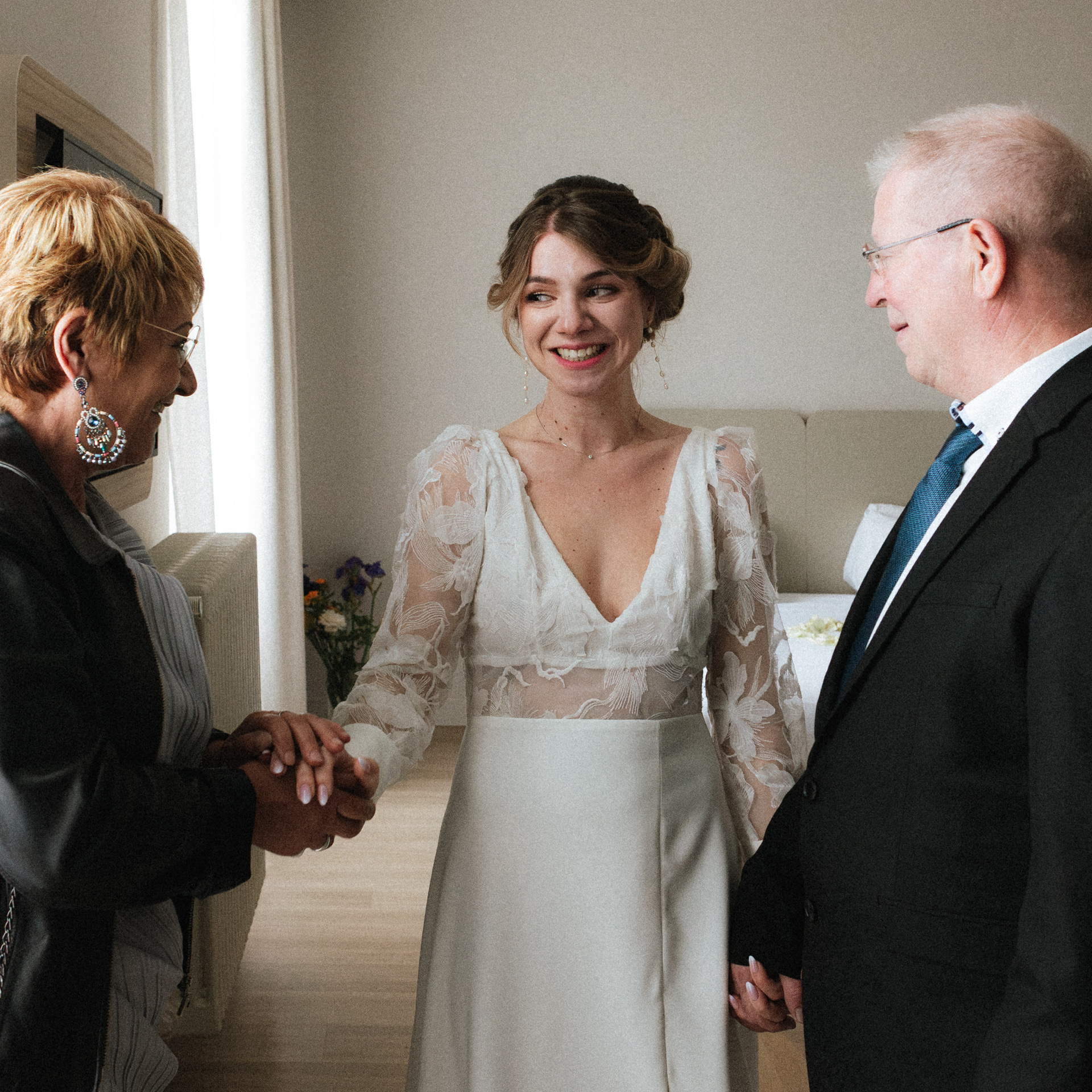 Moment de complicité entre la mariée et ses parents à l'Abbaye des Prémontrés. La mariée sourit à sa maman.