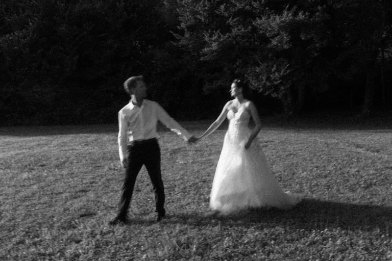 Photo floue et poétique des mariés qui marchent en se tenant la main pendant la séance couple au Domaine de Millanges en Gironde.