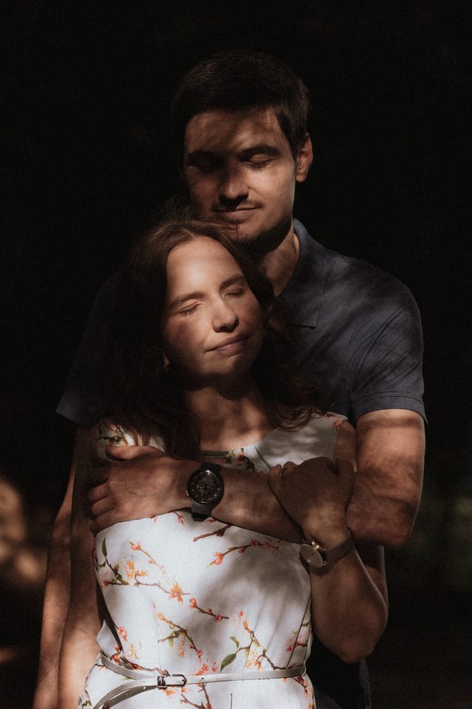 Séance engagement dans le parc du Château Madame de Graffigny. L'homme enlace sa femme, ils sont baignés de lumière