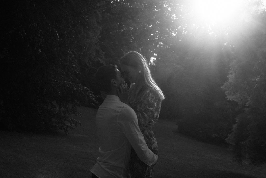 Séance engagement au Parc de la Pépinière à Nancy. Un homme soulève sa future femme et il s'apprête à l'embrasser