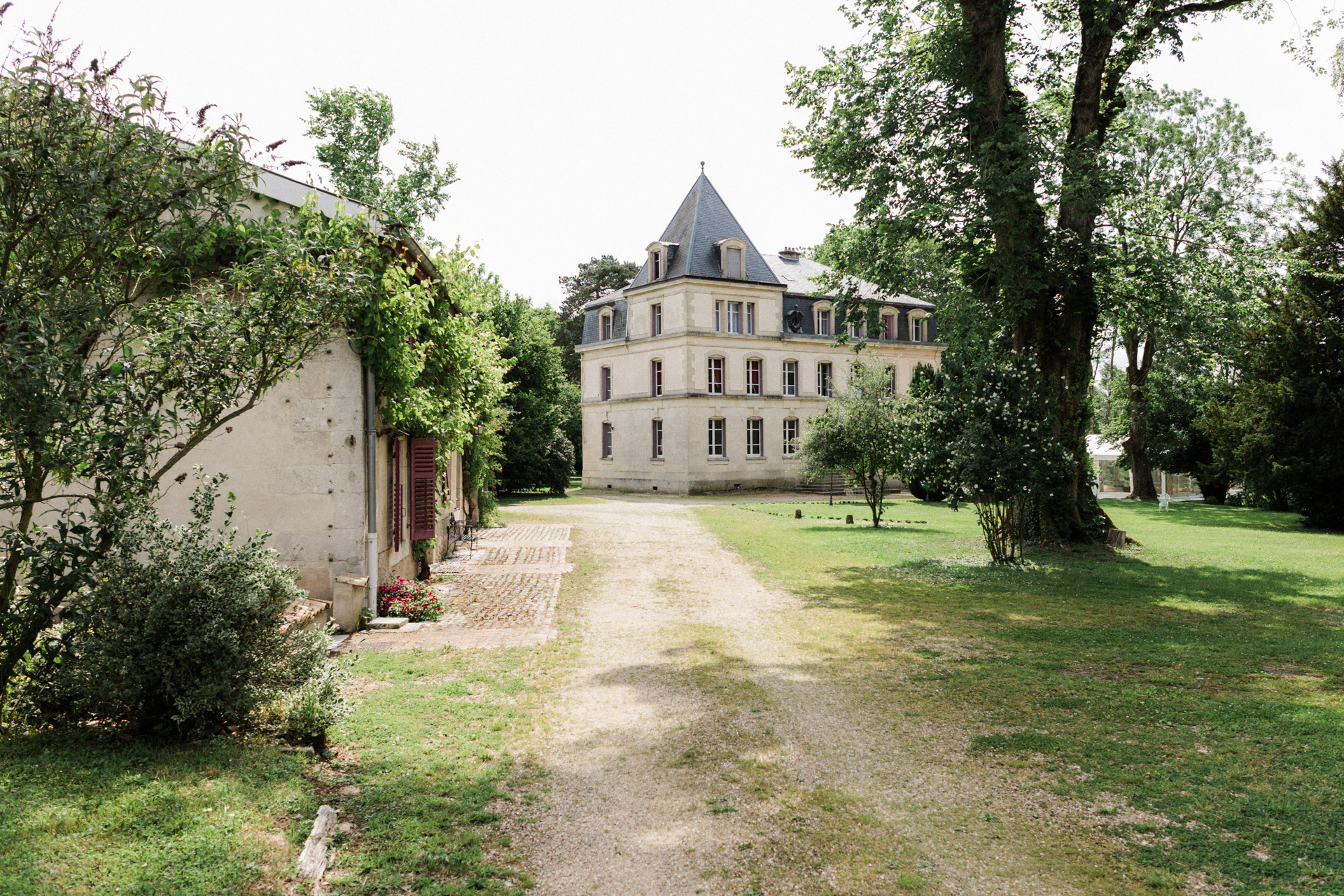 Façade élégante du Château des Aulnes avec grandes fenêtres symétriques et architecture classique entourée de verdure