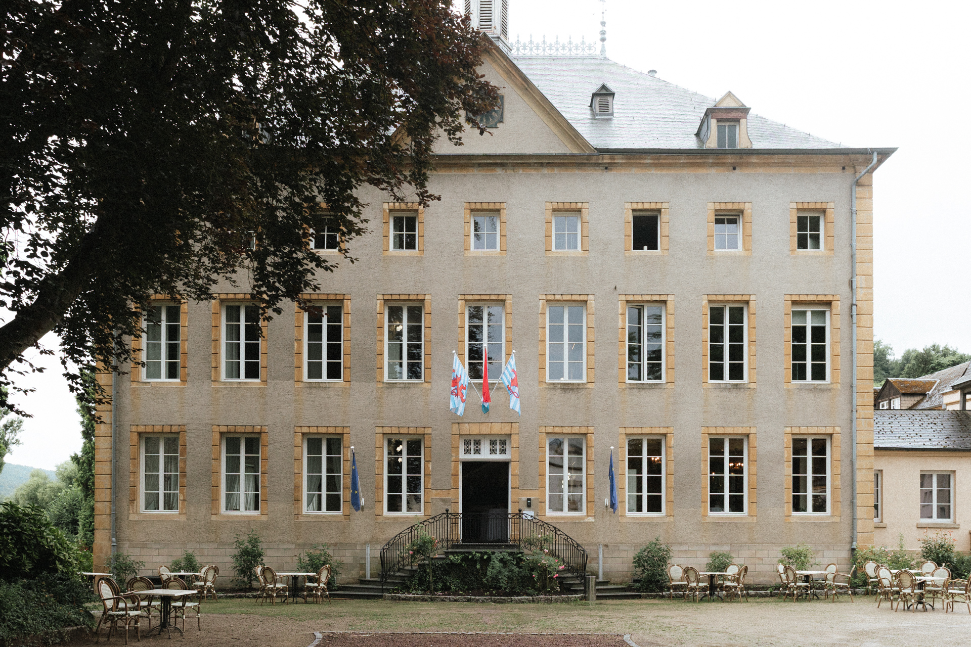 Façade du Château de Schengen au Luxembourg avec fenêtres symétriques et drapeaux, vue sur la cour extérieure