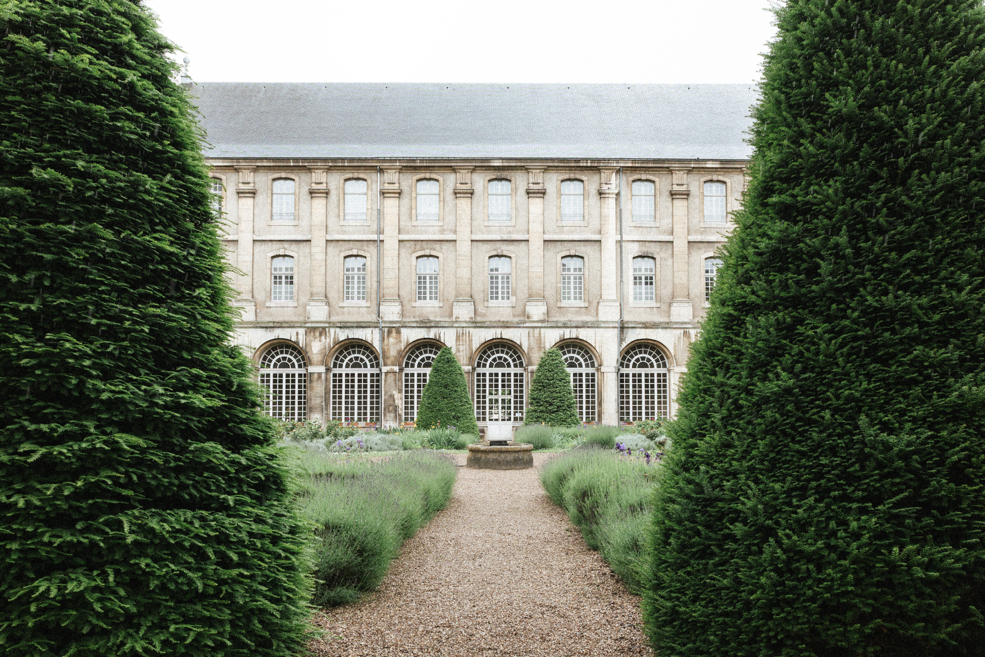 Cour intérieure de l’Abbaye des Prémontrés avec jardin à la française et allée centrale bordée de haies