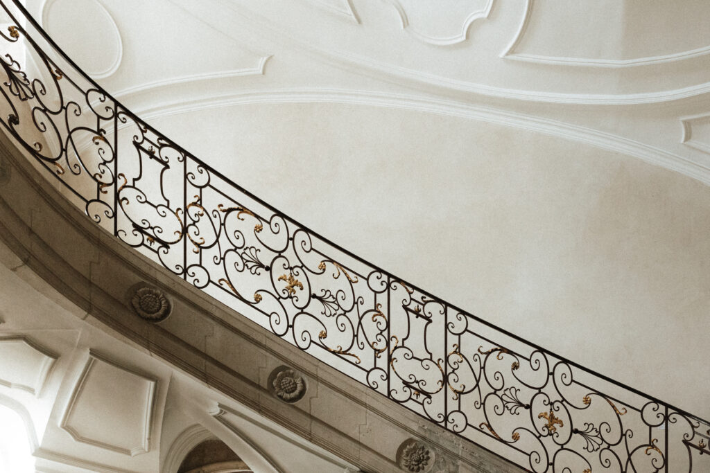 Escalier intérieur orné de ferronnerie décorative dans l’Abbaye des Prémontrés, ambiance élégante et lumineuse