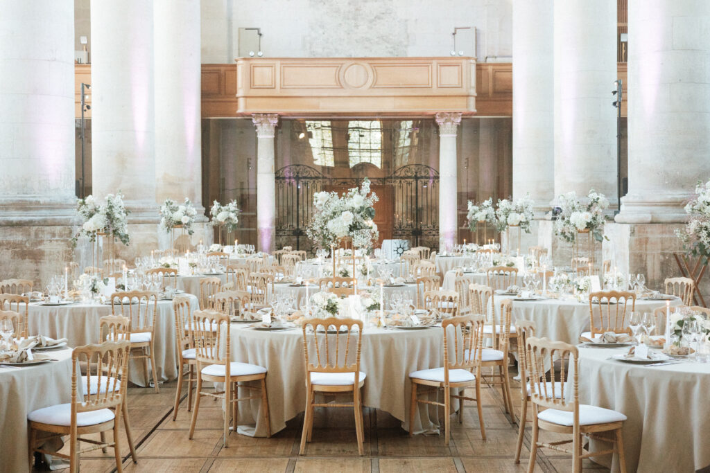 Salle abbatiale de l’Abbaye des Prémontrés décorée pour un mariage, avec tables dressées et compositions florales élégantes
