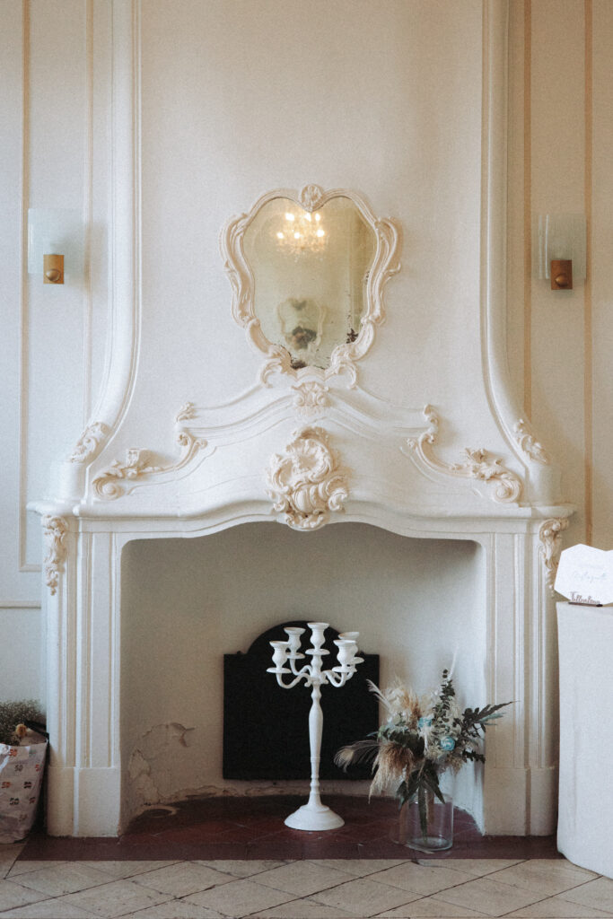 Cheminée ancienne en stuc avec miroir et bougeoir dans un salon élégant du château d’Art-sur-Meurthe