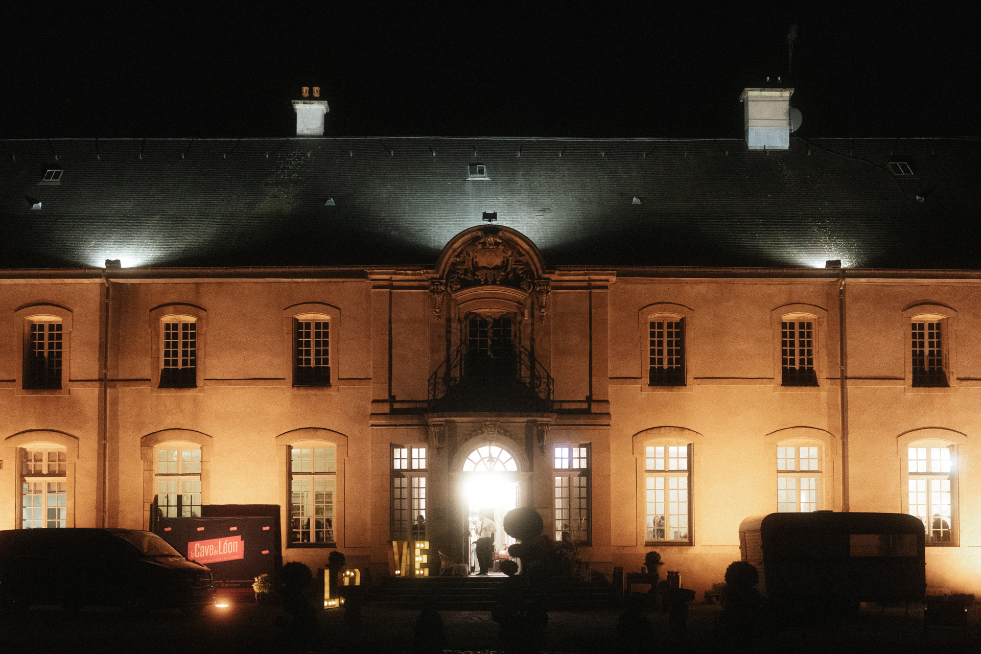 Façade du château d’Art-sur-Meurthe illuminée de nuit avec entrée ouverte et ambiance chaleureuse de réception
