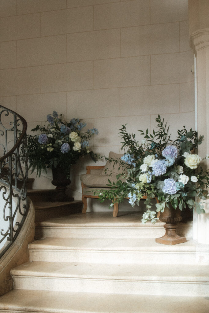 Escalier en pierre décoré de compositions florales aux tons pastel dans le château d’Art-sur-Meurthe