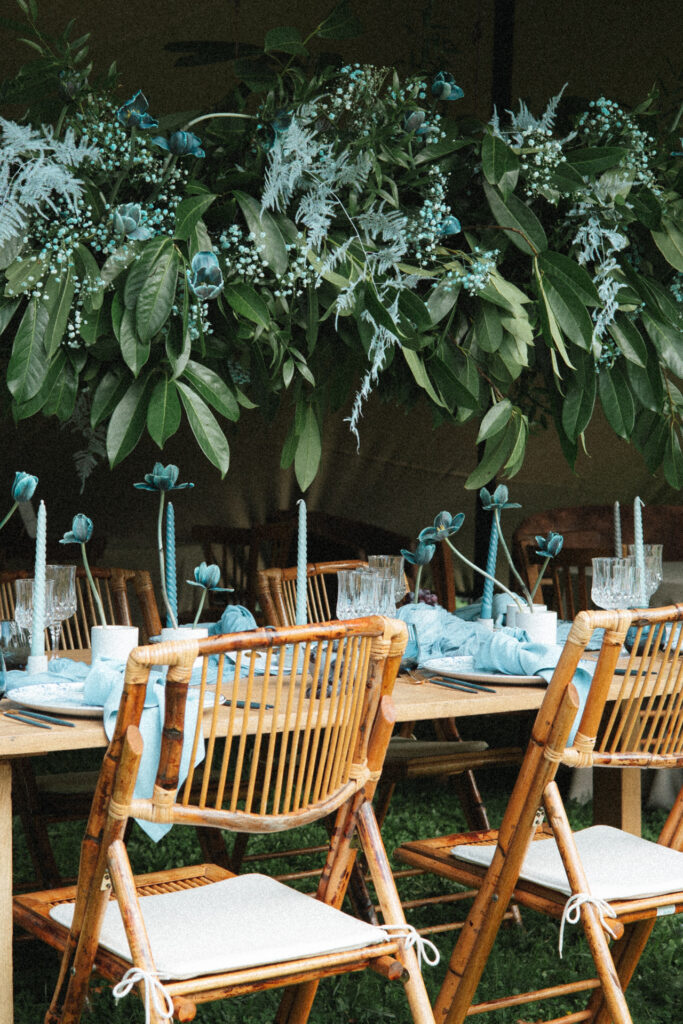 Table de réception décorée de feuillage et fleurs bleutées avec vaisselle élégante pour mariage au château d’Art-sur-Meurthe