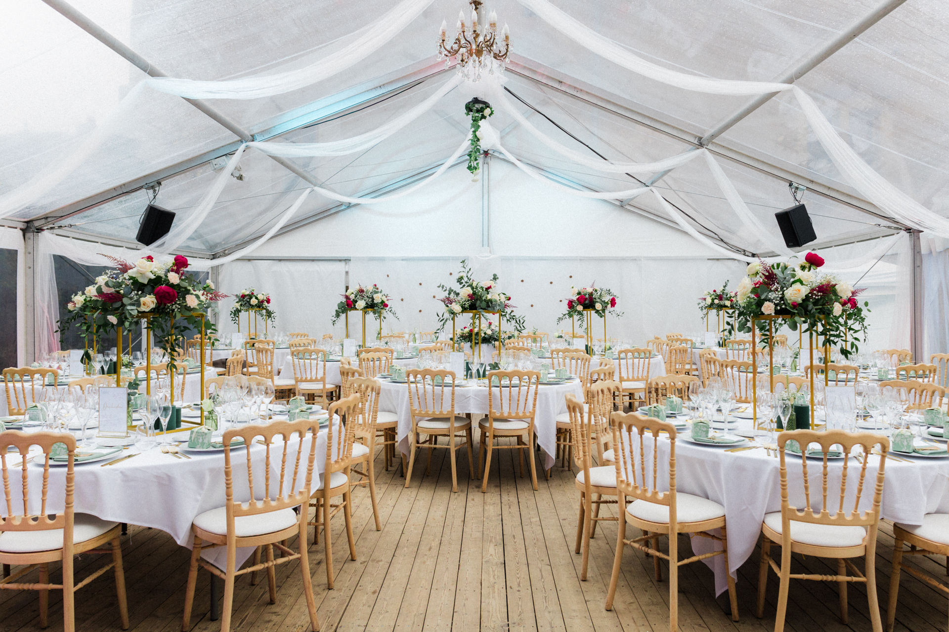 Salle de réception sous chapiteau décorée de fleurs et tables élégantes pour mariage au Château de Jaulny