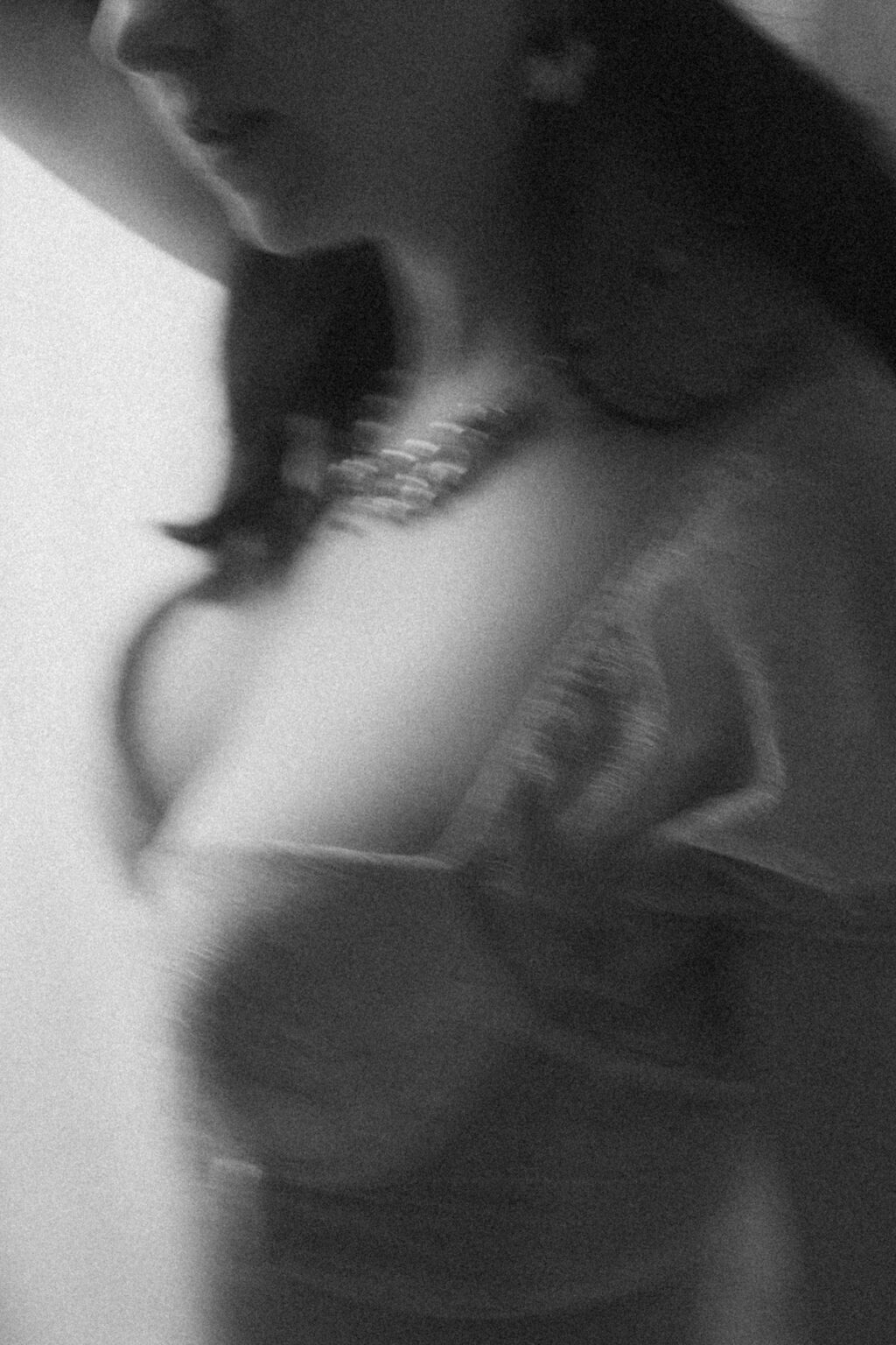 Portrait noir et blanc flou d’une mariée en lingerie, capturé dans une ambiance douce et artistique lors d'une séance boudoir de la mariée.