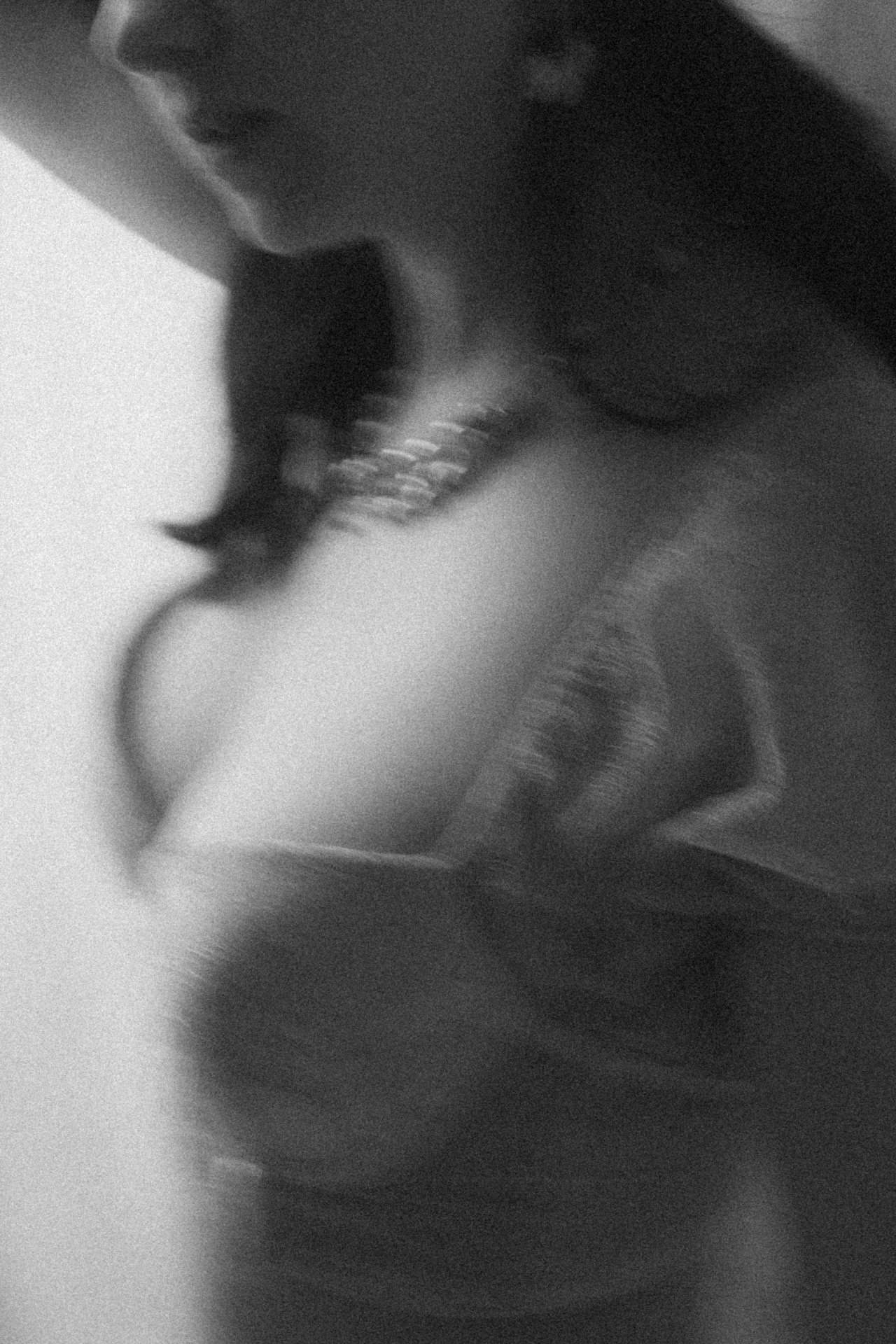 Portrait noir et blanc flou d’une mariée en lingerie, capturé dans une ambiance douce et artistique lors d'une séance boudoir de la mariée.