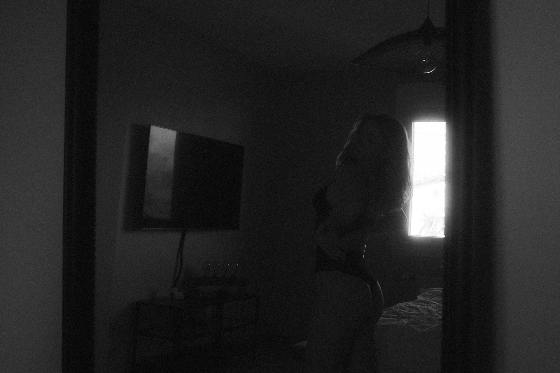 Séance boudoir à Metz avec lingerie noire, une femme prend la pause devant le miroir dans une ambiance intimiste.